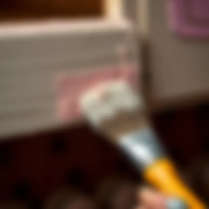 A close-up view of a brush applying paint to a cabinet surface